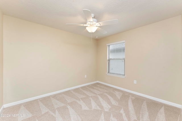 unfurnished room with a textured ceiling, light colored carpet, and ceiling fan