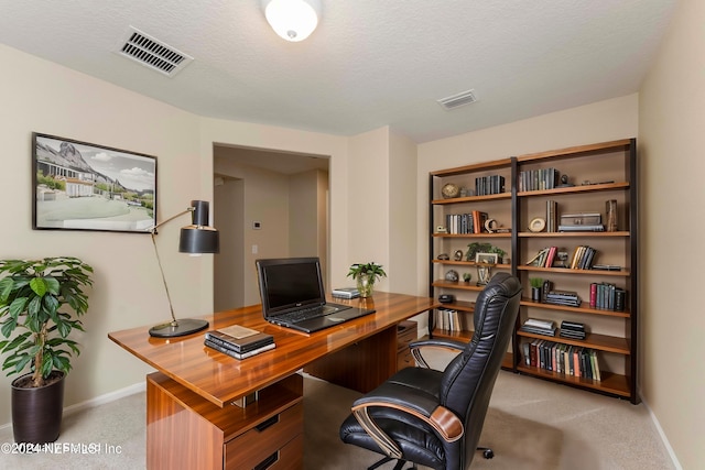 carpeted office with a textured ceiling