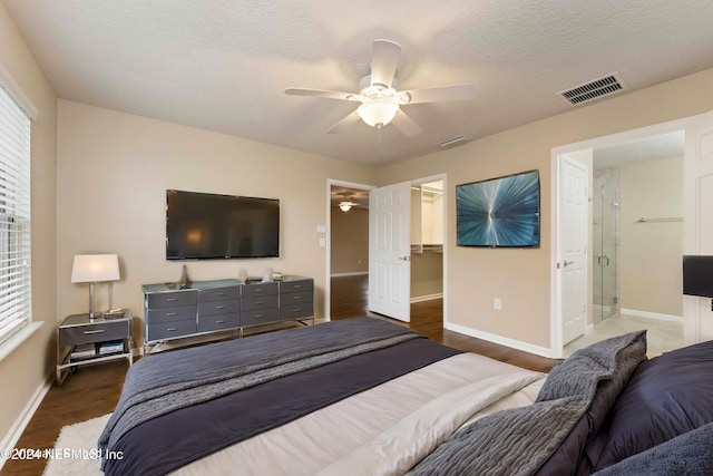 bedroom featuring ceiling fan, a spacious closet, connected bathroom, dark hardwood / wood-style flooring, and a closet