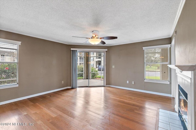 unfurnished living room with plenty of natural light, light hardwood / wood-style floors, and a textured ceiling