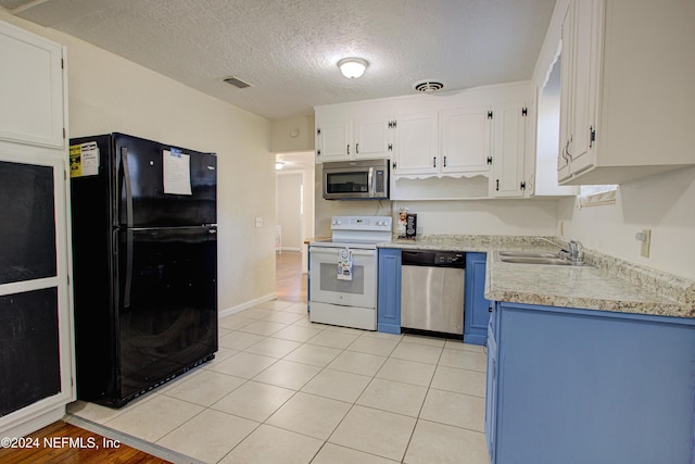 kitchen with light tile patterned floors, stainless steel appliances, light countertops, and white cabinets