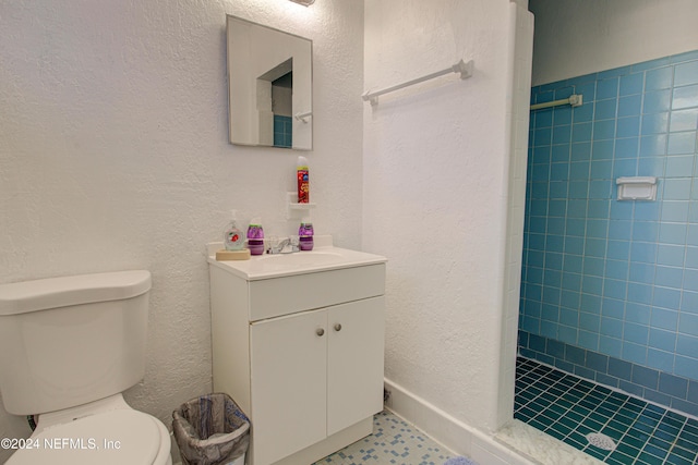 bathroom with tiled shower, a textured wall, vanity, and toilet