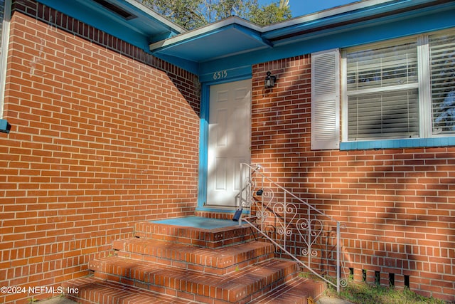 property entrance featuring brick siding