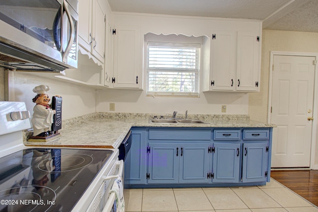 kitchen featuring white range with electric cooktop, white cabinets, stainless steel microwave, light countertops, and a sink