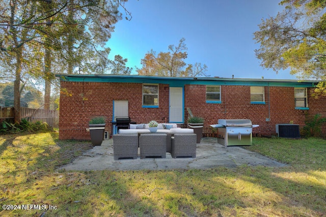 rear view of house with a lawn, a patio, fence, outdoor lounge area, and brick siding