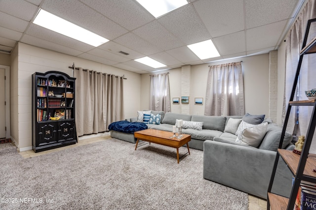 living room featuring carpet flooring and a drop ceiling