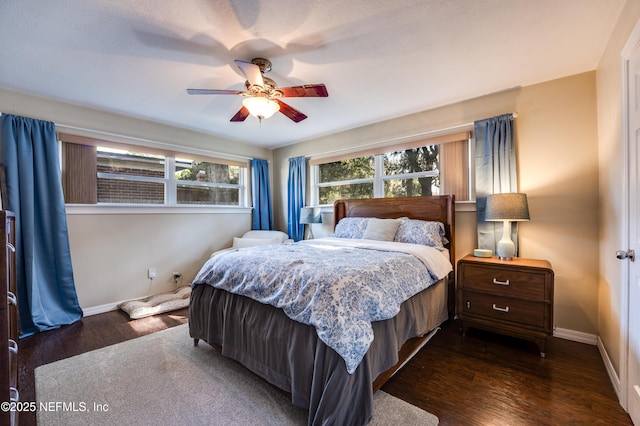 bedroom with a textured ceiling, ceiling fan, and dark wood-type flooring