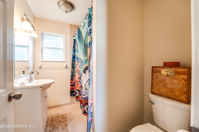 bathroom with tile patterned flooring, vanity, and toilet