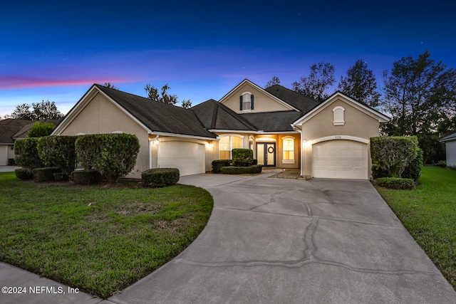 view of front of home featuring a garage and a yard