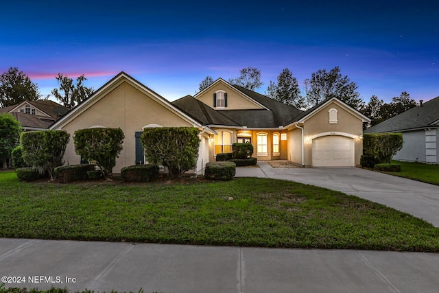 2176 Autumn Cove Cir, Fleming Island, FL 32003 - view of front of house with stucco siding, a garage, driveway, and a lawn