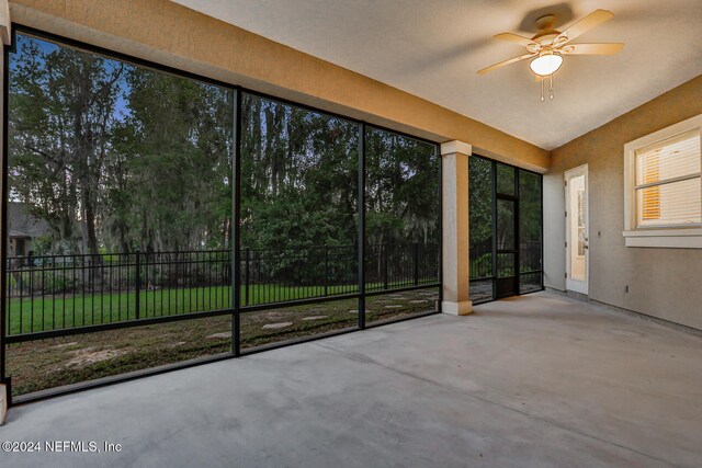 unfurnished sunroom with ceiling fan