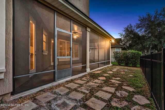 property exterior at dusk with a sunroom