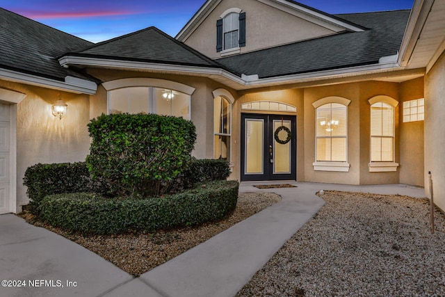 2176 Autumn Cove Cir, Fleming Island, FL 32003 - exterior entry at dusk featuring roof with shingles and stucco siding