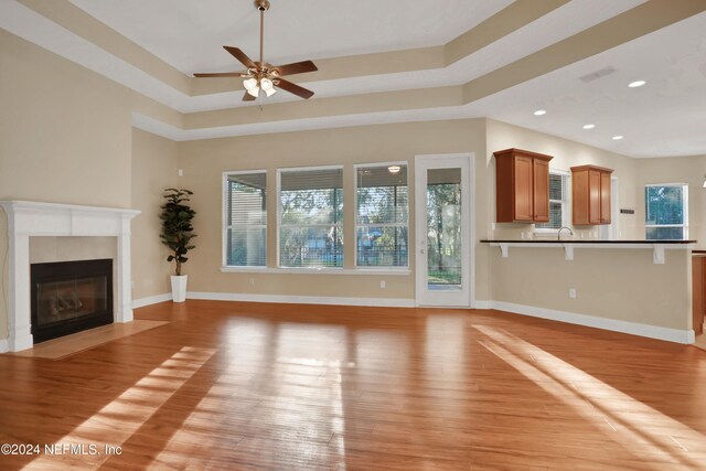 unfurnished living room with ceiling fan, a healthy amount of sunlight, and light hardwood / wood-style flooring