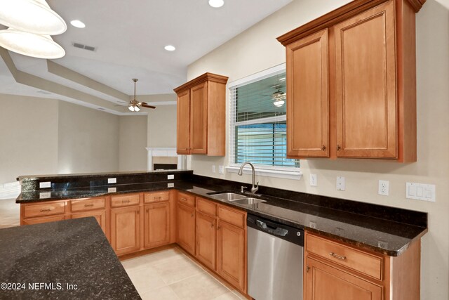 kitchen featuring kitchen peninsula, dishwasher, dark stone counters, and sink