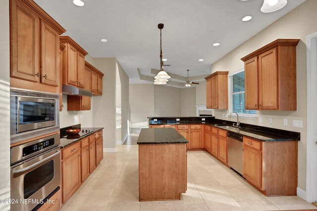 kitchen with appliances with stainless steel finishes, sink, light tile patterned floors, pendant lighting, and a kitchen island