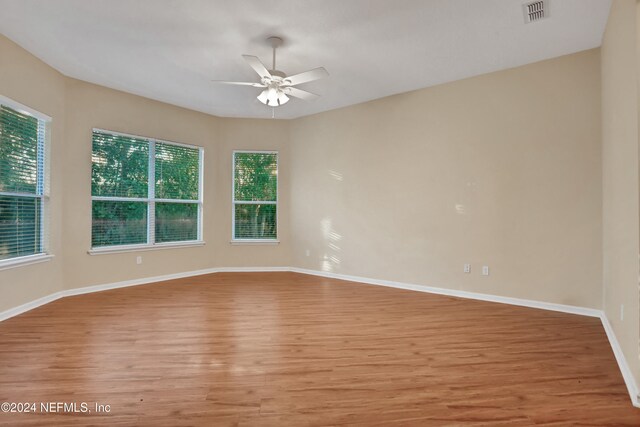 unfurnished room featuring light wood-type flooring, ceiling fan, and a healthy amount of sunlight