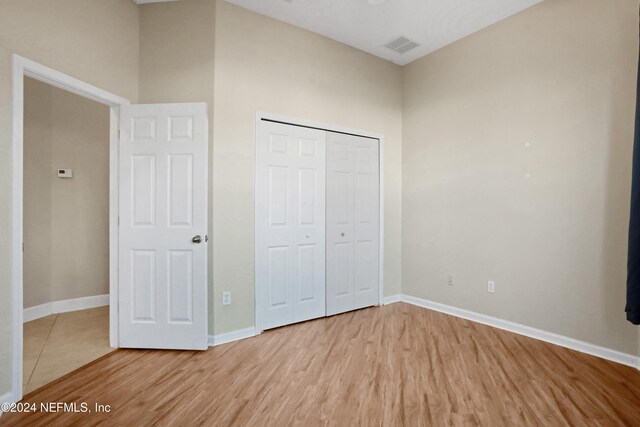 unfurnished bedroom featuring a closet and light hardwood / wood-style floors