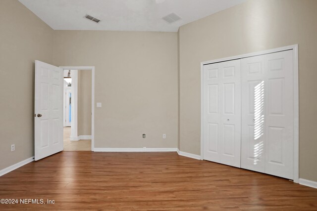 unfurnished bedroom featuring hardwood / wood-style floors and a closet