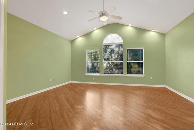 unfurnished room with hardwood / wood-style floors, ceiling fan, and vaulted ceiling