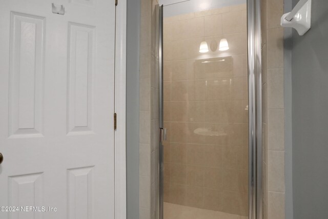 bathroom with a shower with door