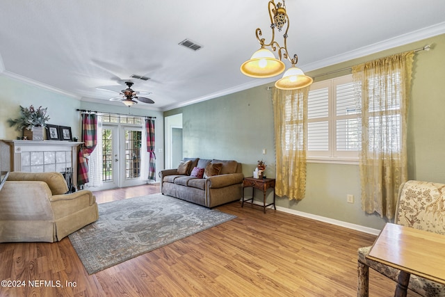 living room with ceiling fan, crown molding, and light hardwood / wood-style flooring