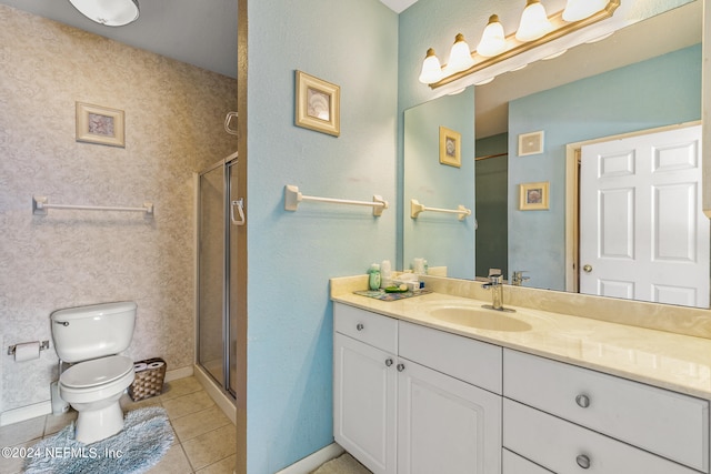 bathroom featuring tile patterned flooring, vanity, toilet, and a shower with shower door