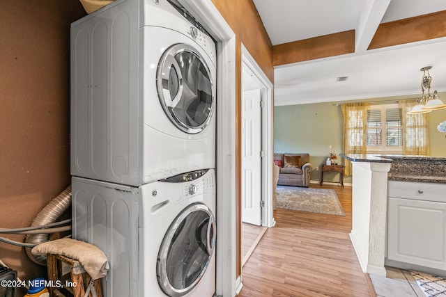 laundry area featuring light hardwood / wood-style flooring and stacked washer / drying machine