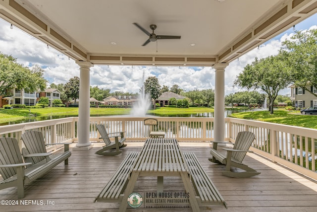 deck with a water view and ceiling fan