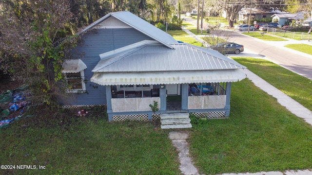 bungalow with covered porch and a front yard