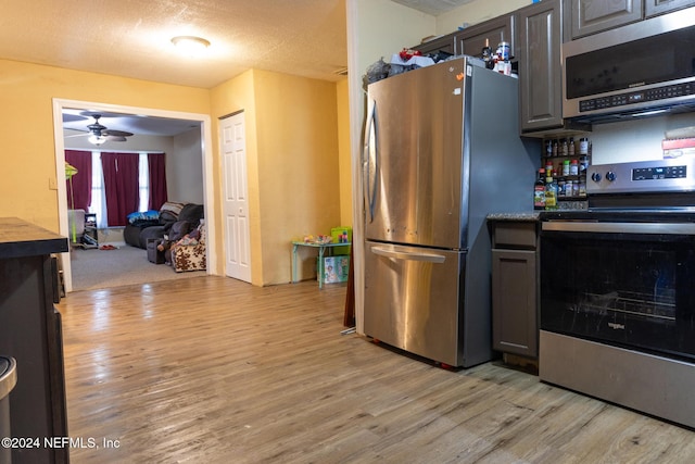 kitchen with a textured ceiling, ceiling fan, light hardwood / wood-style floors, and stainless steel appliances