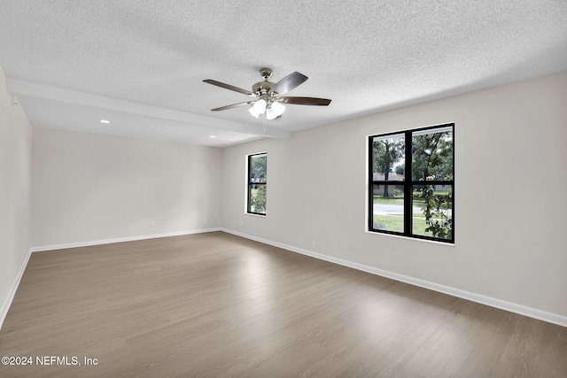 unfurnished room with hardwood / wood-style floors, ceiling fan, and a textured ceiling