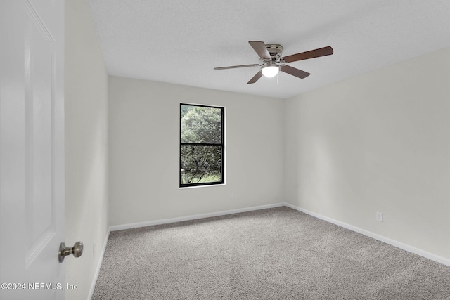 carpeted spare room with a textured ceiling and ceiling fan