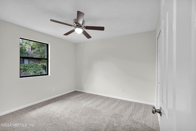 unfurnished room with carpet, ceiling fan, and a textured ceiling