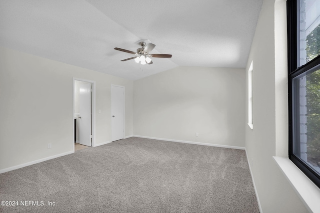 spare room with ceiling fan, light colored carpet, lofted ceiling, and a textured ceiling