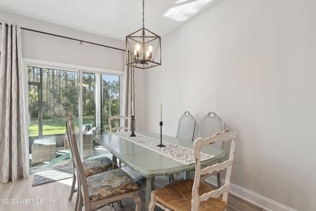 dining area with light hardwood / wood-style floors and an inviting chandelier