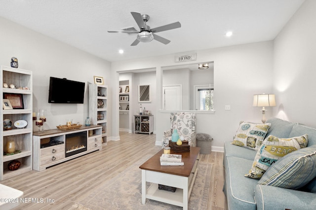 living room with wood-type flooring and ceiling fan