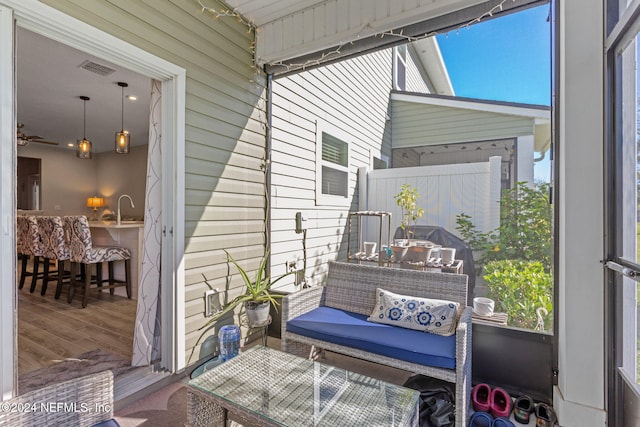 sunroom / solarium featuring ceiling fan, plenty of natural light, and sink