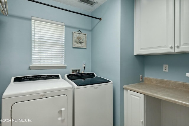 washroom with washer and clothes dryer and cabinets