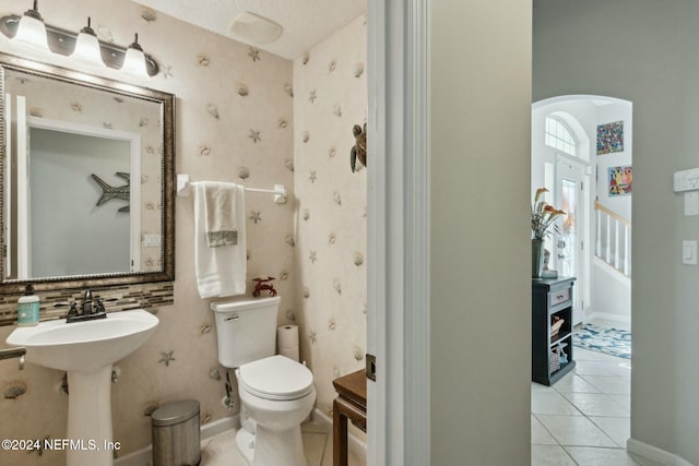 bathroom with tile patterned floors, sink, a textured ceiling, and toilet