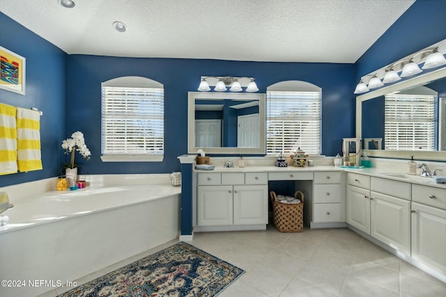 bathroom featuring a bathtub, vanity, and a textured ceiling