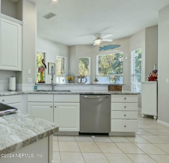 kitchen featuring stainless steel dishwasher, sink, white cabinets, and a textured ceiling