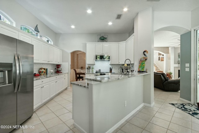 kitchen featuring white cabinets, appliances with stainless steel finishes, and decorative backsplash