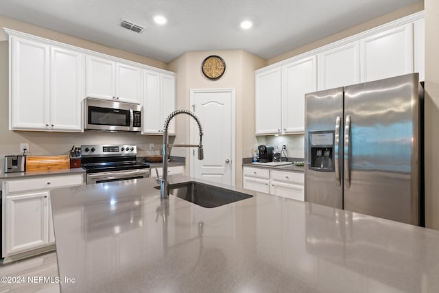 kitchen with sink, white cabinetry, and stainless steel appliances