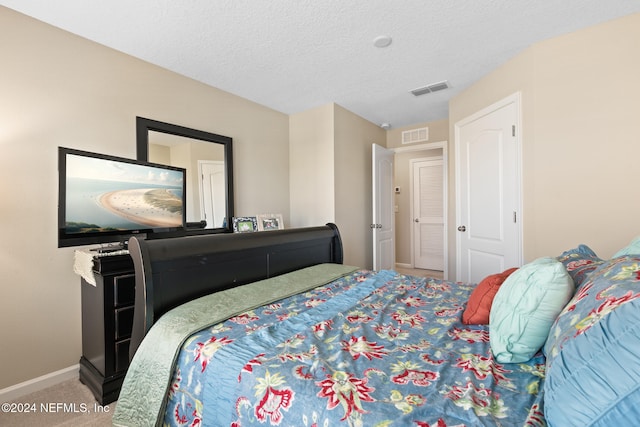 bedroom with carpet and a textured ceiling