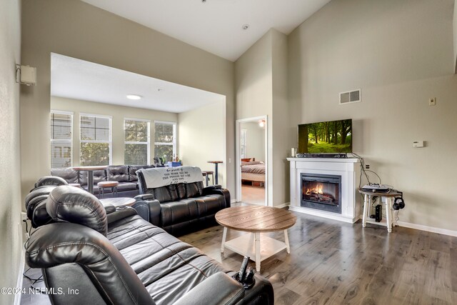 living room with hardwood / wood-style floors and high vaulted ceiling