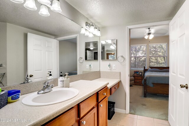 bathroom featuring tile patterned floors, ceiling fan, a textured ceiling, and vanity