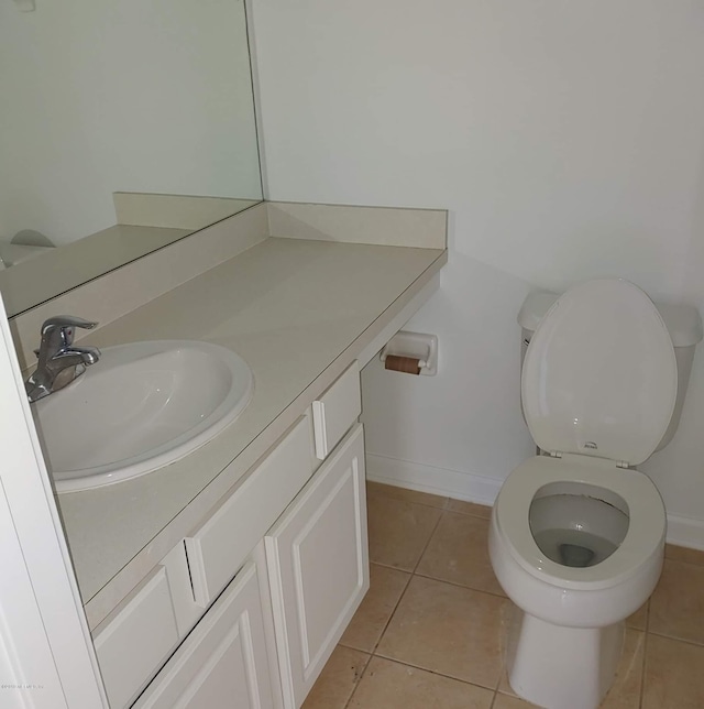 bathroom with tile patterned flooring, vanity, and toilet