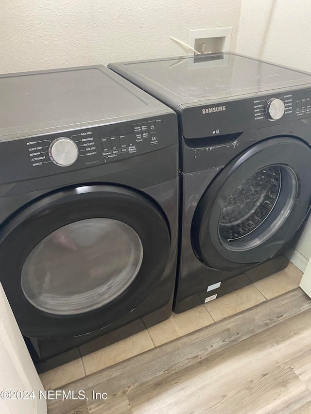 laundry room with hardwood / wood-style floors and independent washer and dryer