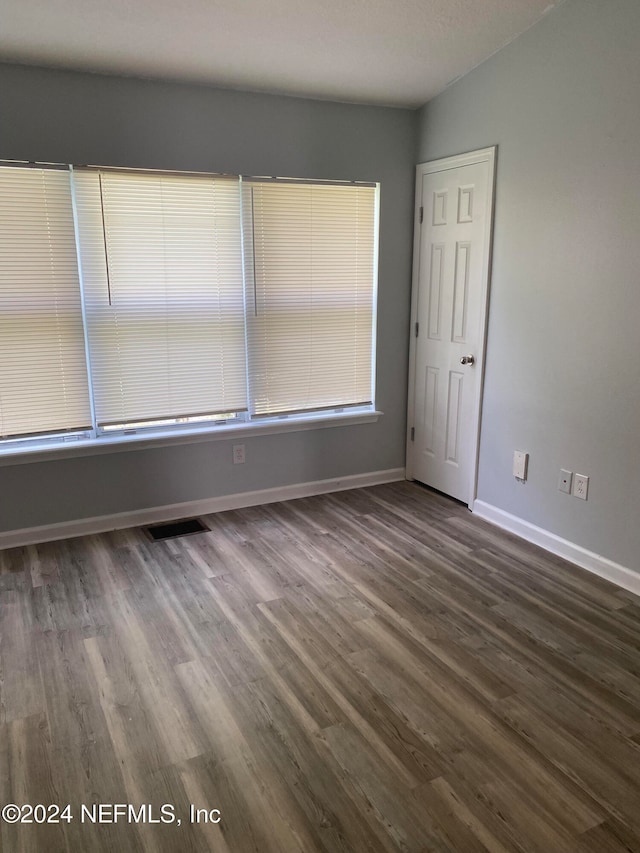 empty room with dark hardwood / wood-style flooring